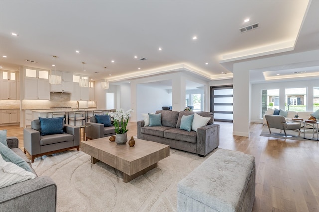 living room featuring light wood-style floors, recessed lighting, and visible vents