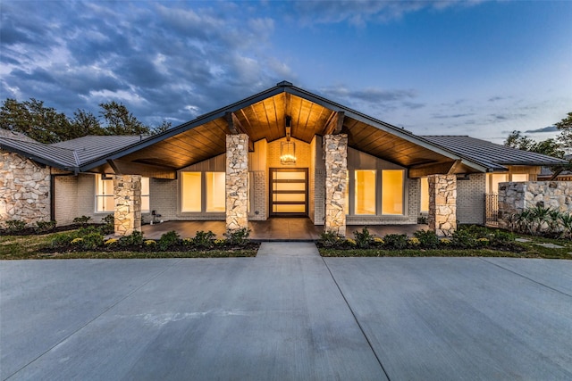 contemporary home with a standing seam roof, metal roof, and stone siding