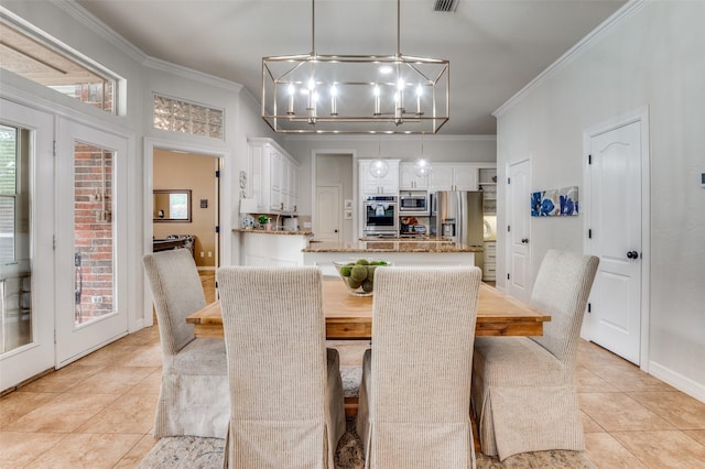 dining space featuring an inviting chandelier, ornamental molding, and light tile patterned floors