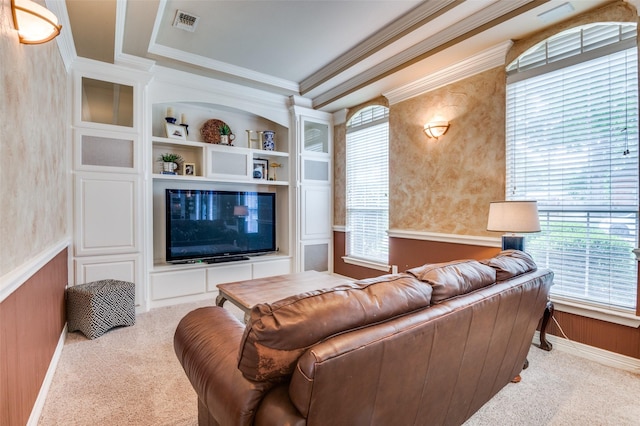 living area with carpet, a wealth of natural light, built in shelves, and ornamental molding