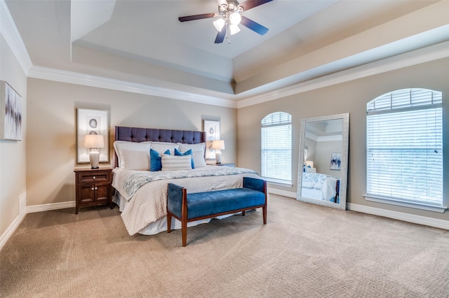 bedroom with baseboards, light colored carpet, ceiling fan, crown molding, and a raised ceiling