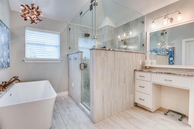 full bathroom with a freestanding tub, vanity, and a stall shower
