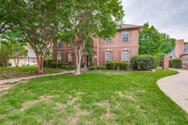 view of front of home featuring fence, brick siding, and a front yard