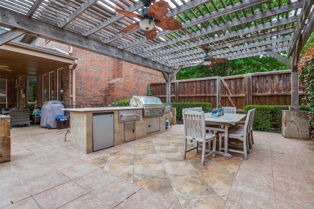 view of patio featuring exterior kitchen, a fenced backyard, outdoor dining space, ceiling fan, and grilling area