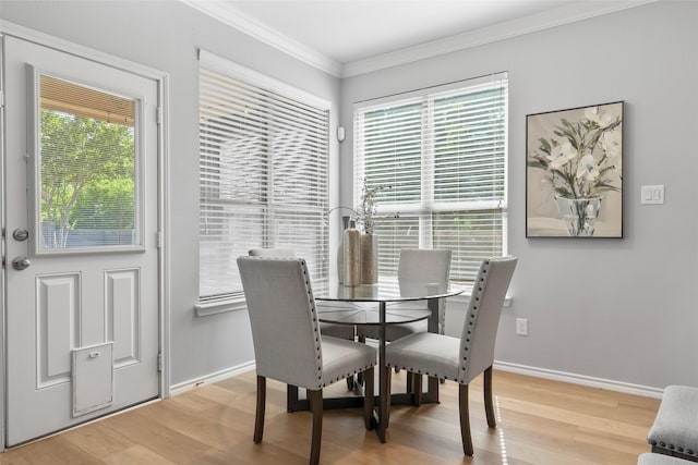 dining area with crown molding, light wood-style flooring, and baseboards