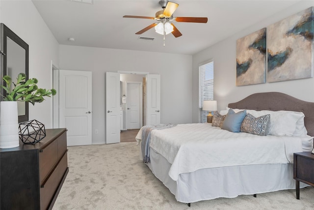 bedroom featuring visible vents, a ceiling fan, and light carpet