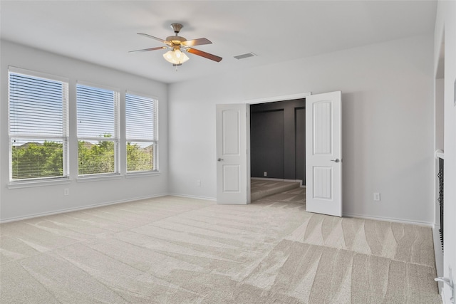 unfurnished bedroom featuring carpet floors, a ceiling fan, baseboards, and visible vents