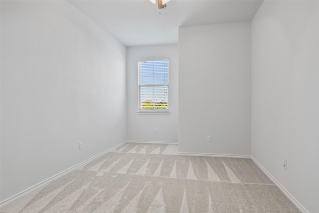 empty room with baseboards and light carpet