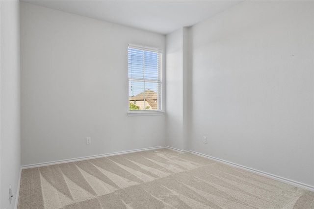 carpeted spare room with baseboards