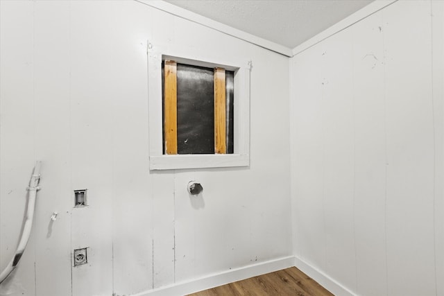 empty room featuring baseboards, wood finished floors, and a textured ceiling