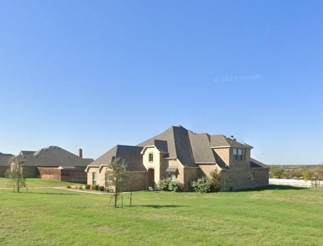view of side of property featuring fence and a lawn