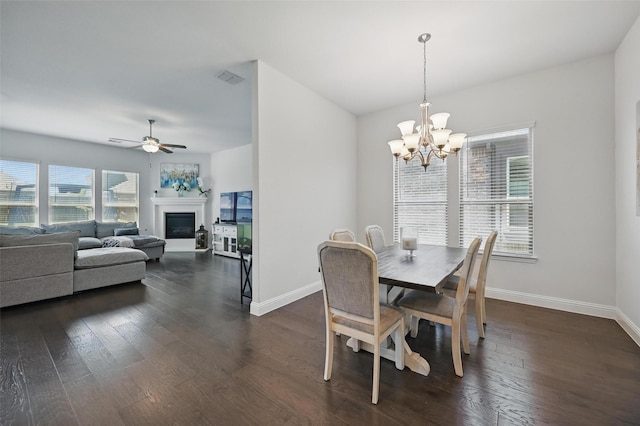 dining area featuring dark wood finished floors, baseboards, visible vents, and ceiling fan with notable chandelier