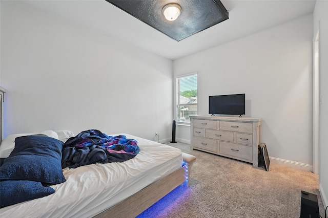 bedroom featuring light colored carpet and baseboards