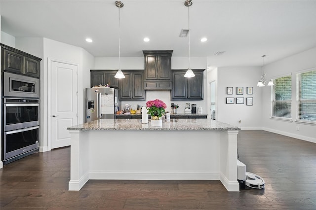 1244 Tiana St, Anna, TX 75409 - kitchen with stainless steel appliances, dark wood finished floors, a large island with sink, light stone counters, and baseboards