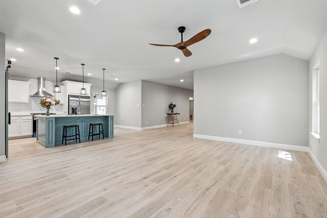 unfurnished living room featuring baseboards, a ceiling fan, light wood-style flooring, and recessed lighting
