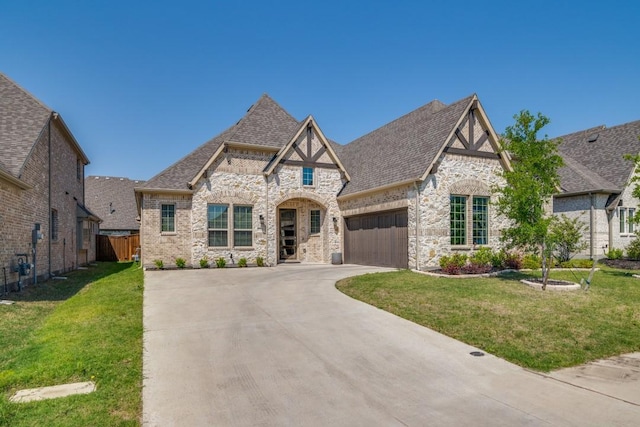 view of front facade with an attached garage, driveway, stone siding, and a front yard