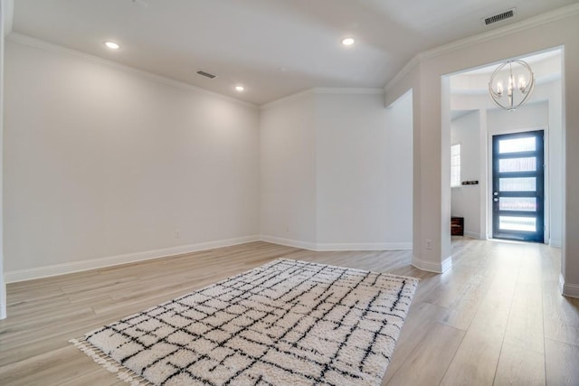 entryway featuring light wood-style flooring, visible vents, a notable chandelier, and crown molding