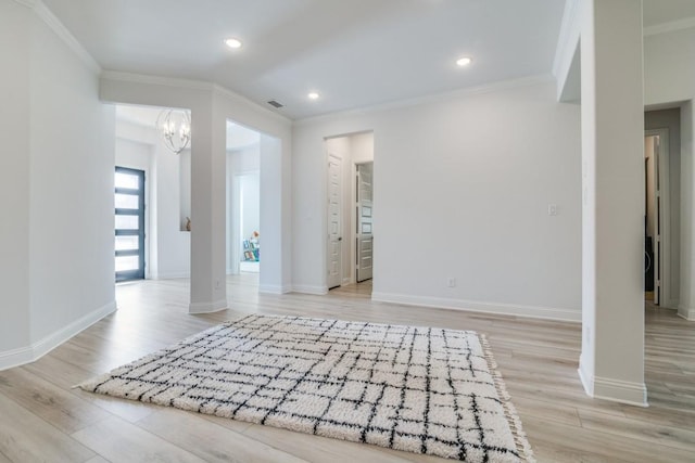 interior space featuring a notable chandelier, baseboards, ornamental molding, and light wood-type flooring