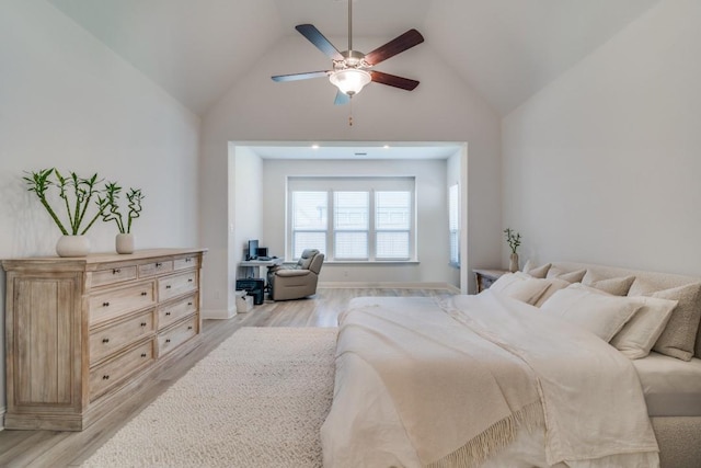bedroom with light wood-type flooring, lofted ceiling, and a ceiling fan
