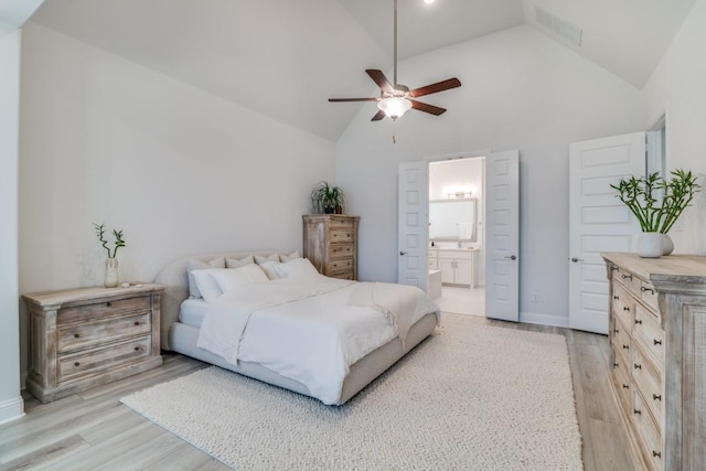 bedroom with light wood finished floors, visible vents, high vaulted ceiling, ceiling fan, and ensuite bathroom