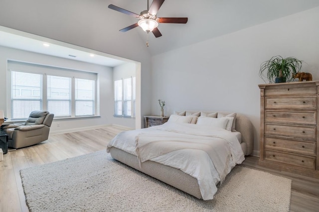 bedroom featuring lofted ceiling, a ceiling fan, wood finished floors, and baseboards