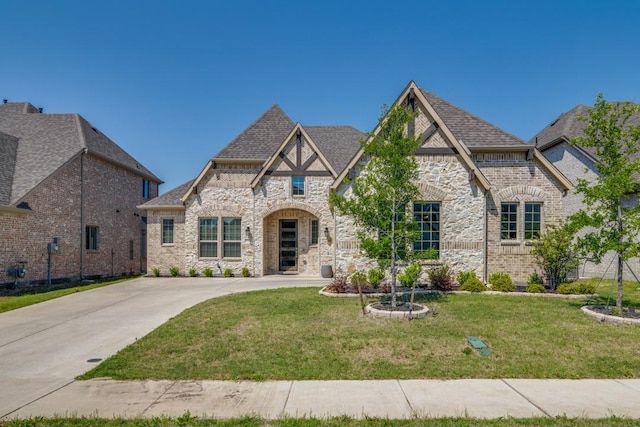 view of front of house with brick siding, stone siding, a shingled roof, and a front yard