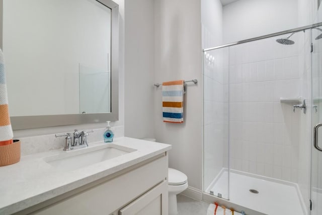 full bathroom featuring vanity, a shower stall, and toilet