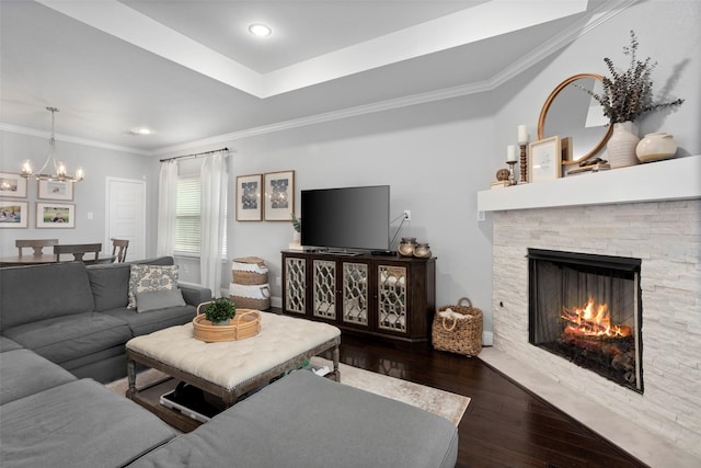 living room with recessed lighting, a stone fireplace, wood finished floors, crown molding, and a chandelier
