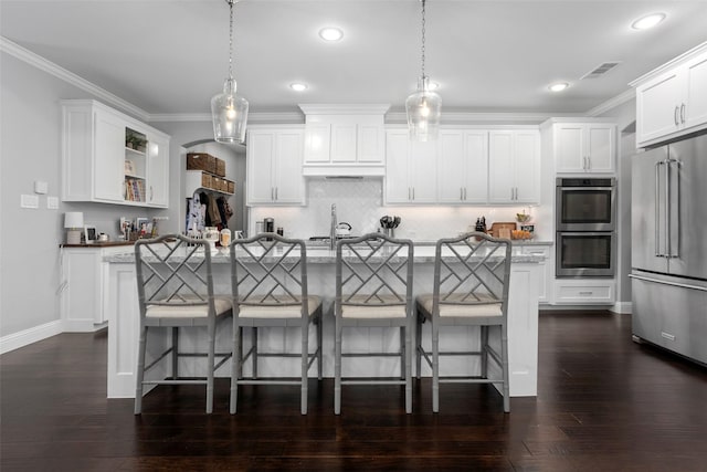 kitchen featuring open shelves, visible vents, appliances with stainless steel finishes, and a breakfast bar