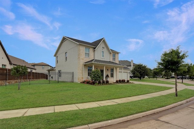 traditional-style home featuring stone siding, board and batten siding, fence, a front yard, and a standing seam roof