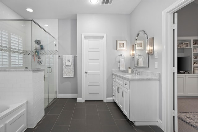 bathroom with tile patterned floors, a stall shower, a bath, vanity, and baseboards