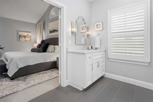 bedroom with baseboards, lofted ceiling, and dark tile patterned flooring
