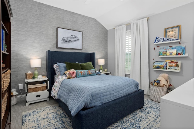 bedroom featuring lofted ceiling and wallpapered walls