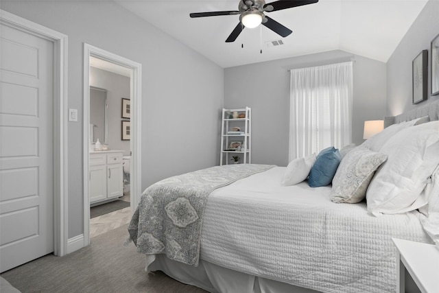 bedroom with ensuite bath, vaulted ceiling, visible vents, and a ceiling fan
