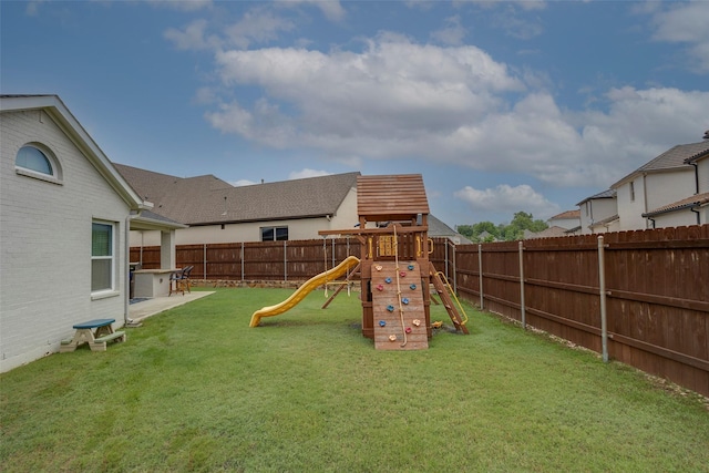view of playground featuring a yard and a fenced backyard