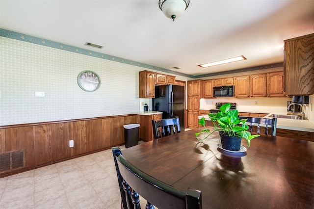 dining area featuring light floors, wallpapered walls, and visible vents