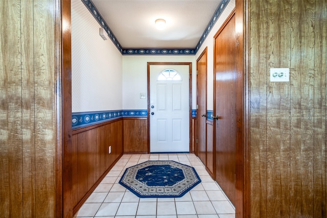 doorway to outside with light tile patterned flooring and wooden walls
