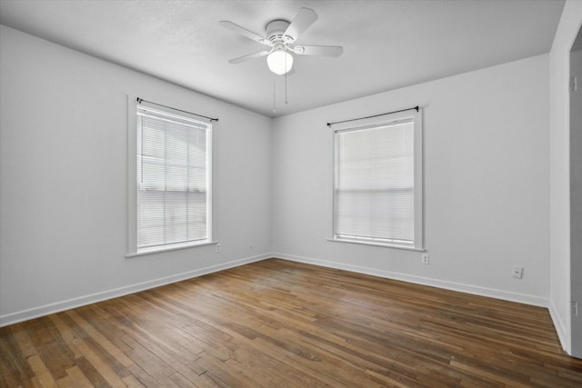 empty room with baseboards, a ceiling fan, and hardwood / wood-style floors
