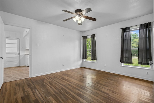 spare room with hardwood / wood-style flooring, baseboards, and a ceiling fan