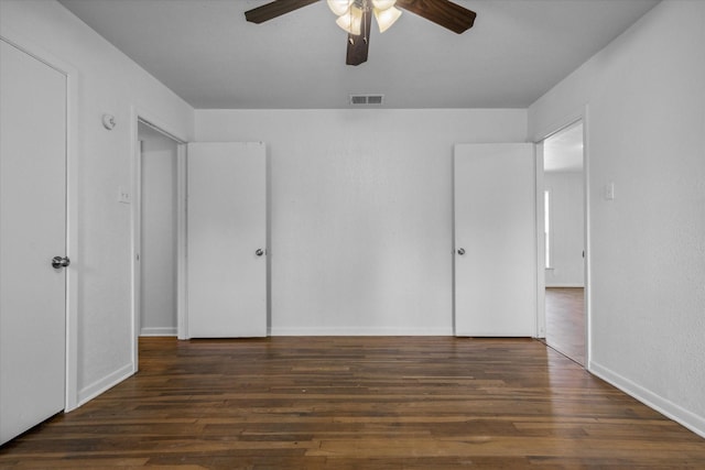unfurnished bedroom featuring wood finished floors, visible vents, a ceiling fan, and baseboards