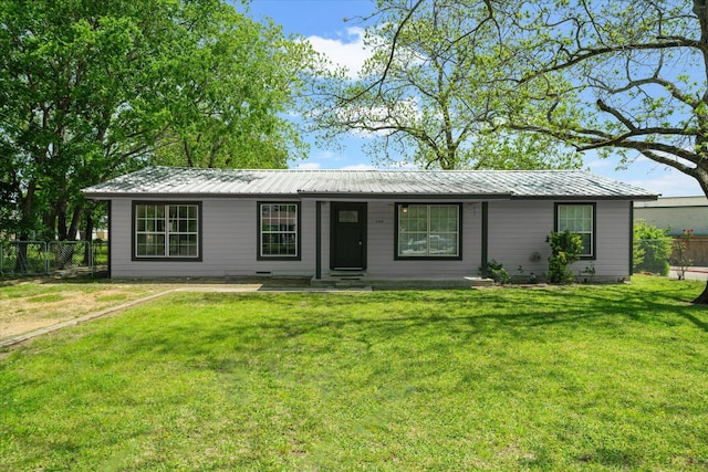 single story home with metal roof, a front lawn, and fence
