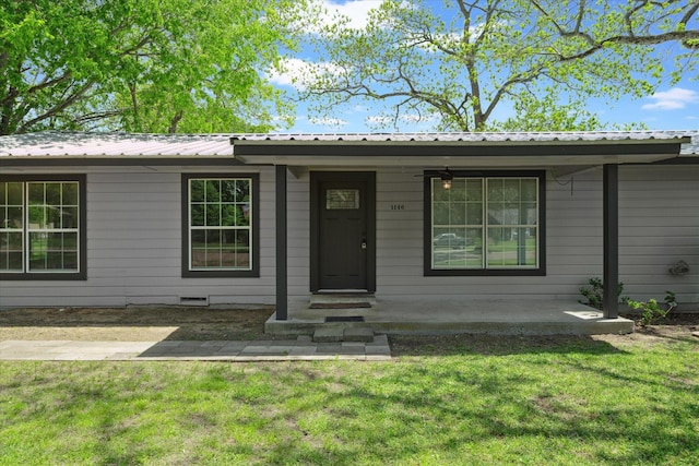 ranch-style house featuring a front lawn and metal roof