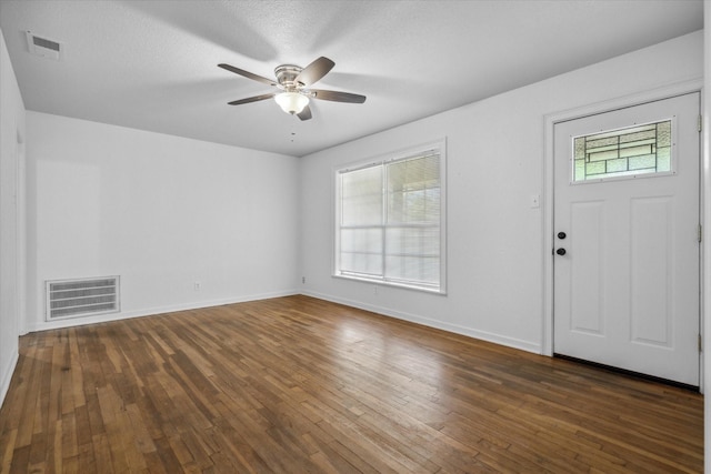 entryway featuring baseboards, visible vents, ceiling fan, and dark wood finished floors