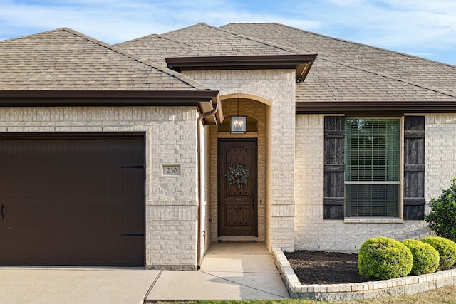 230 Heatherstone Dr, Midlothian, TX 76065 - view of exterior entry featuring an attached garage, brick siding, and a shingled roof