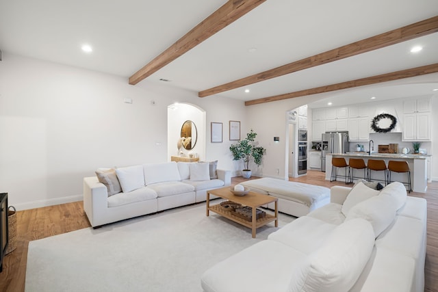 230 Heatherstone Dr, Midlothian, TX 76065 - living room with arched walkways, light wood-type flooring, recessed lighting, baseboards, and beamed ceiling