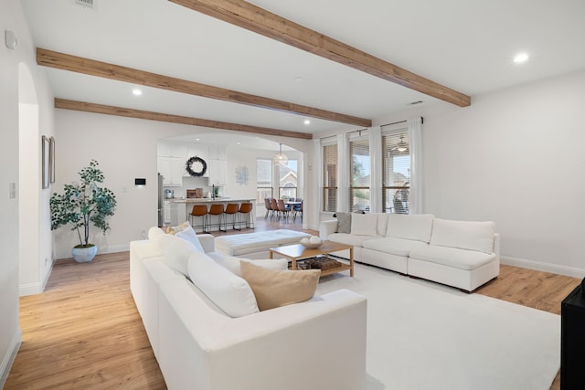 230 Heatherstone Dr, Midlothian, TX 76065 - living room featuring arched walkways, light wood-style floors, baseboards, recessed lighting, and beam ceiling