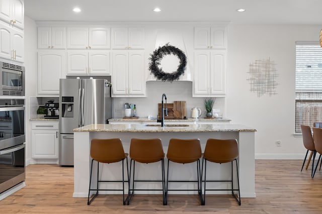 230 Heatherstone Dr, Midlothian, TX 76065 - kitchen featuring a sink, stainless steel appliances, a kitchen bar, decorative backsplash, and recessed lighting