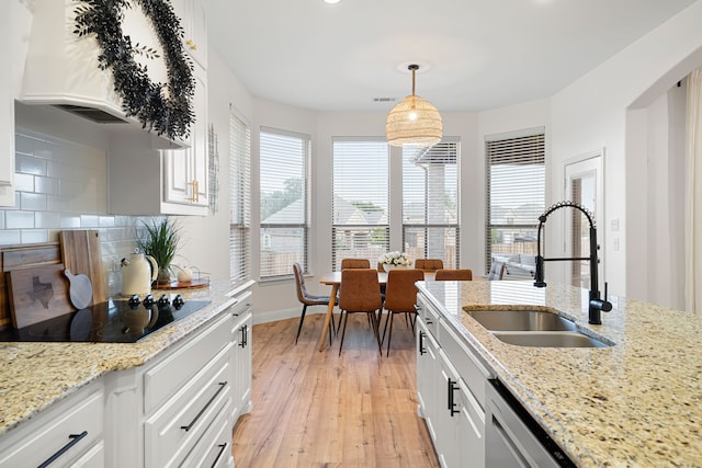 230 Heatherstone Dr, Midlothian, TX 76065 - kitchen featuring a sink, black electric cooktop, light wood-type flooring, decorative backsplash, and white cabinets