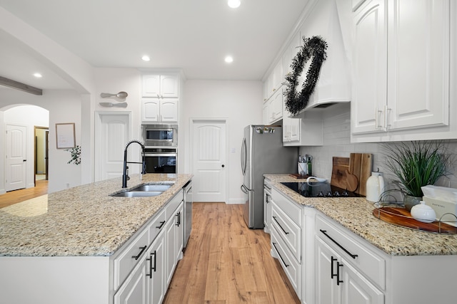 230 Heatherstone Dr, Midlothian, TX 76065 - kitchen featuring stainless steel appliances, a sink, arched walkways, backsplash, and white cabinetry