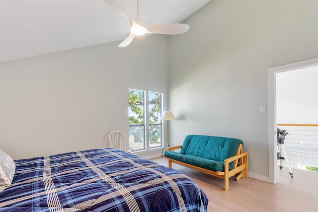 bedroom with light wood-style floors, baseboards, a ceiling fan, and high vaulted ceiling